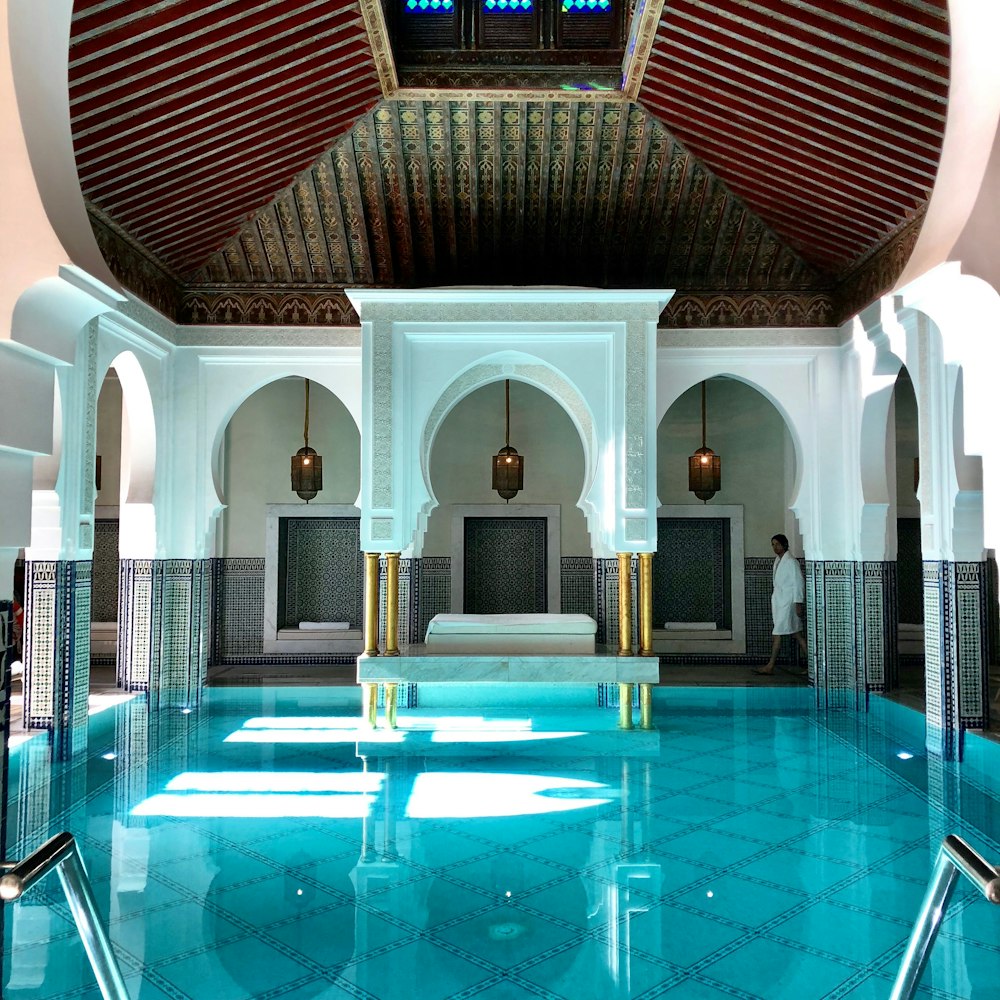 a large indoor swimming pool with blue tiles