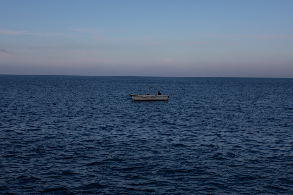 a small boat floating on top of a large body of water