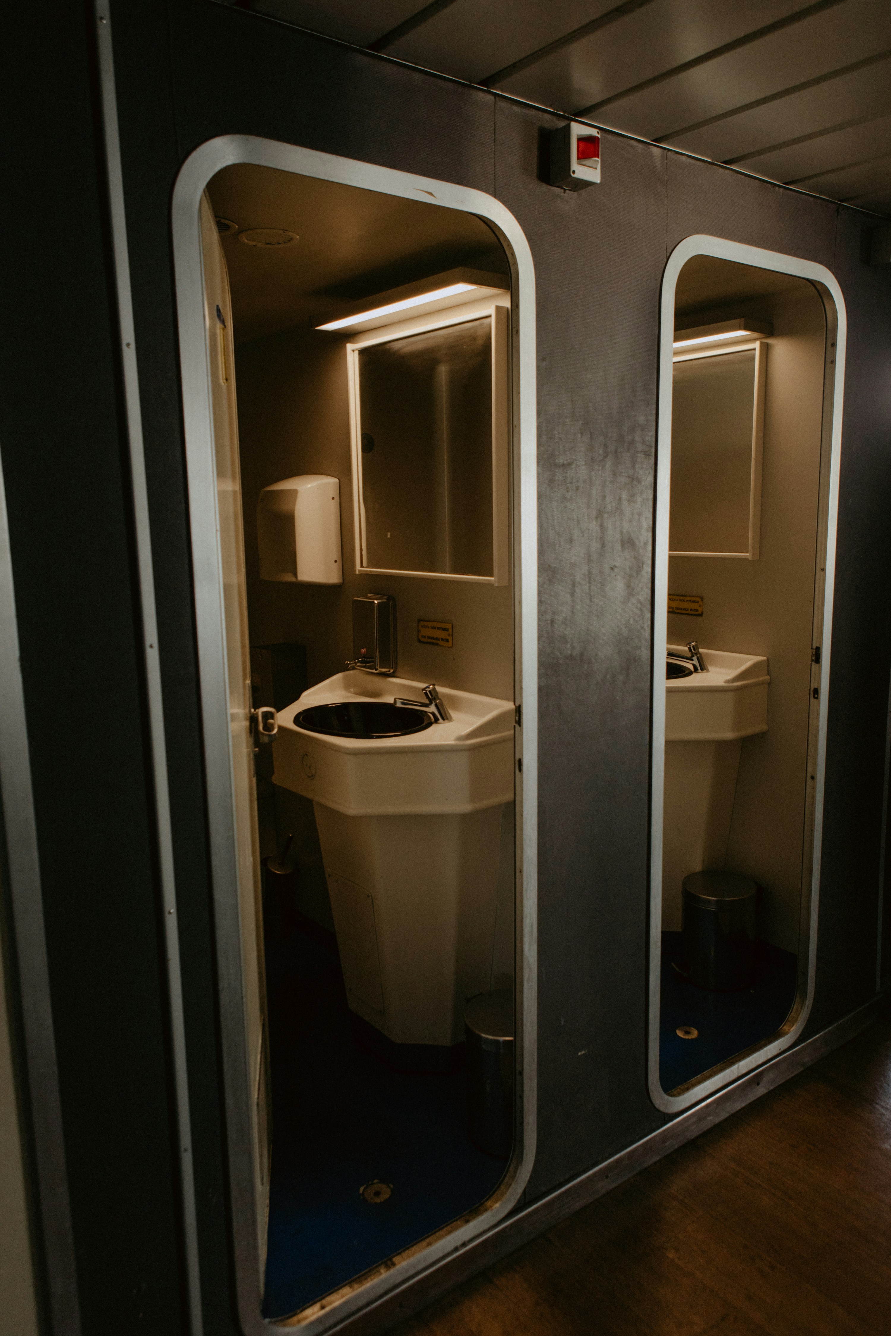 une salle de bain avec un lavabo et deux miroirs