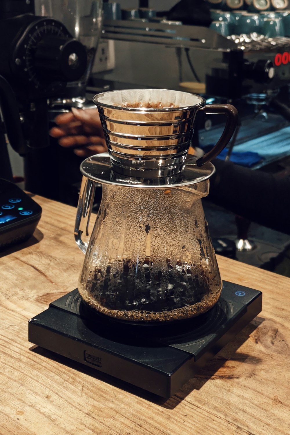 eine Kaffeekanne aus Glas, die auf einem Holztisch steht