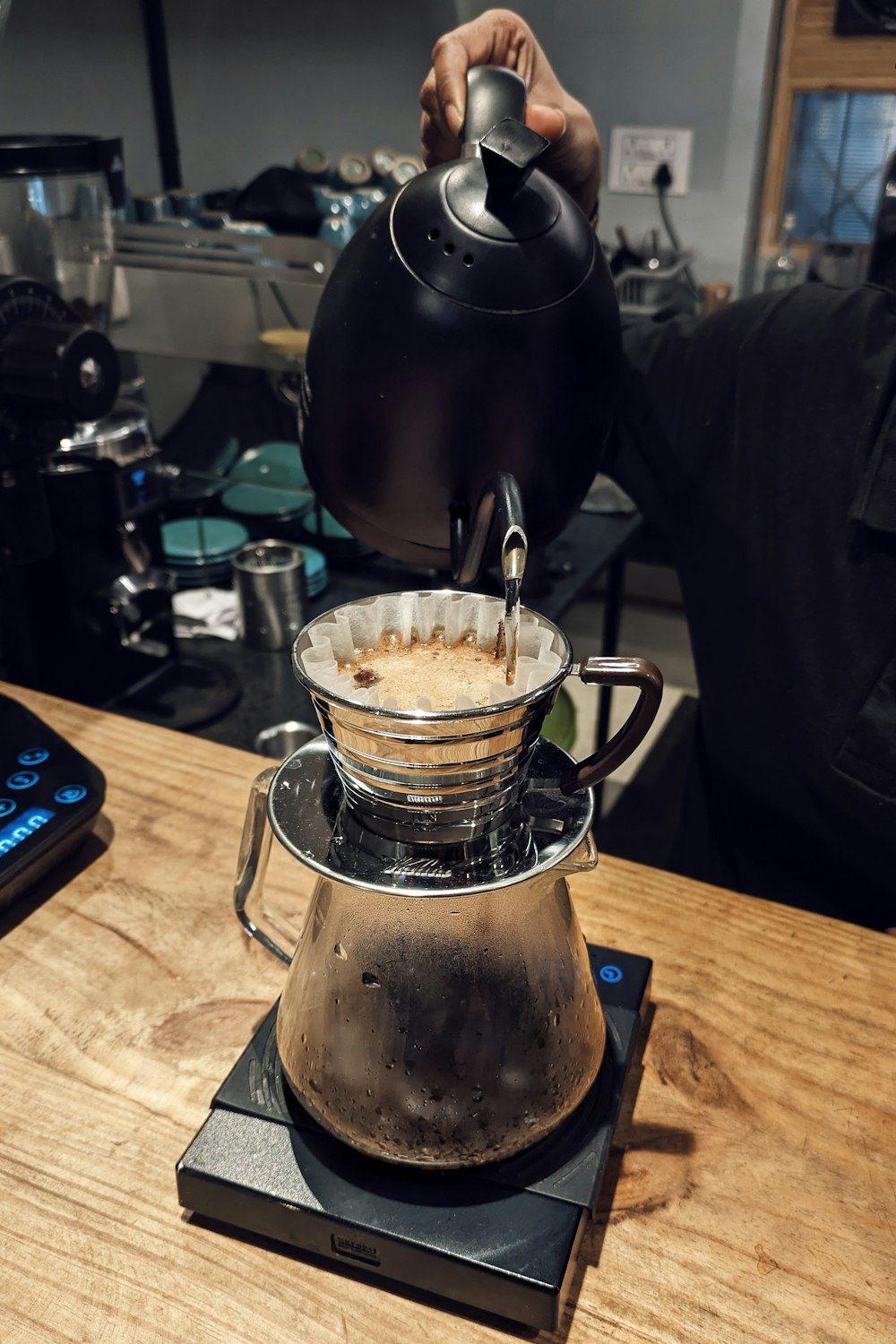 a person pours coffee into a coffee pot