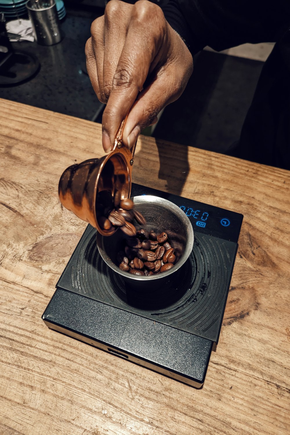 a person pouring coffee into a pot on top of a stove