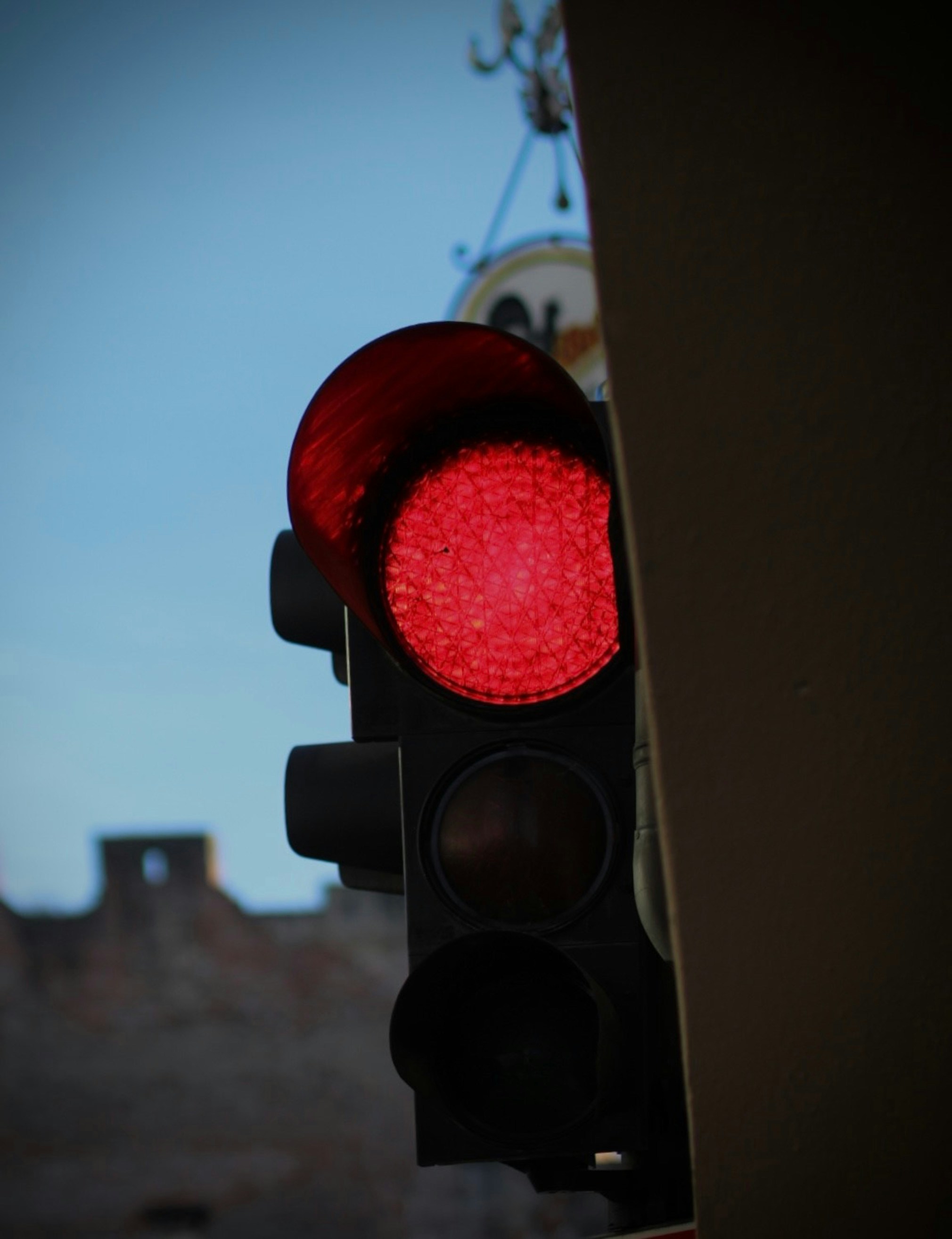 a red traffic light with a building in the background