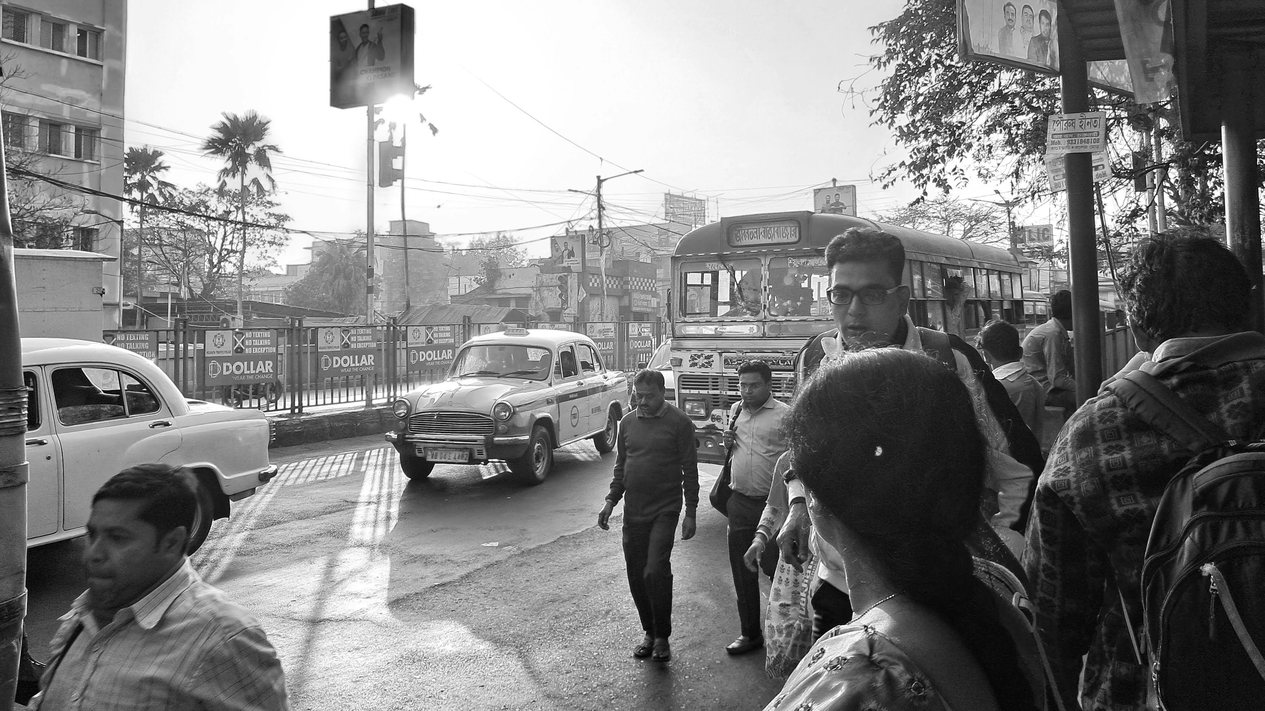 a group of people walking down a street next to a traffic light