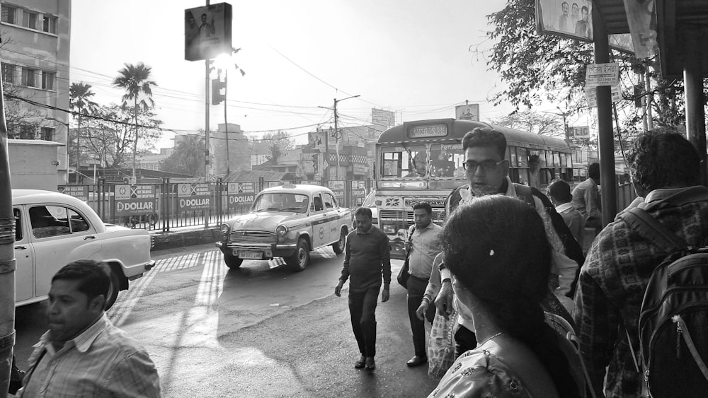 a group of people walking down a street next to a traffic light