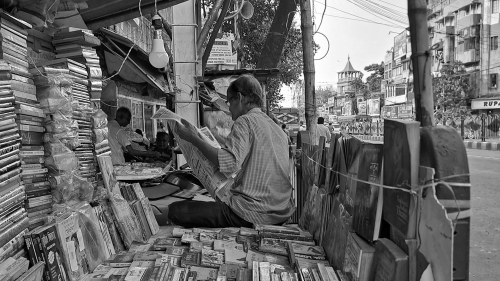 a man sitting in the back of a truck filled with books