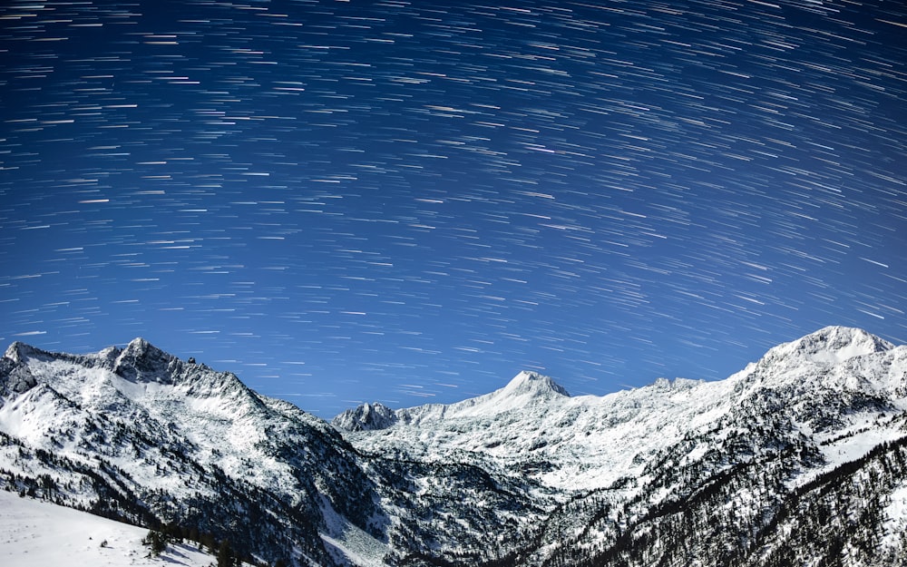 the night sky over a snowy mountain range