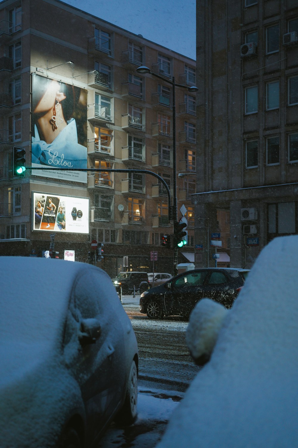 a city street with cars covered in snow