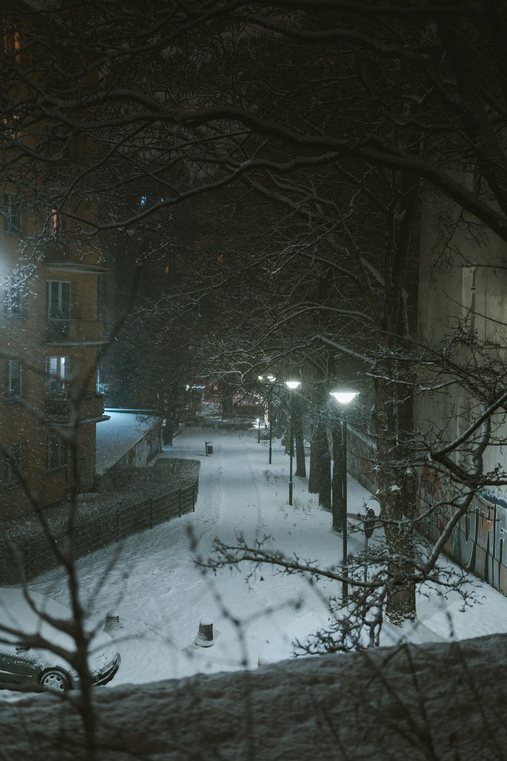 a city street is covered in snow at night