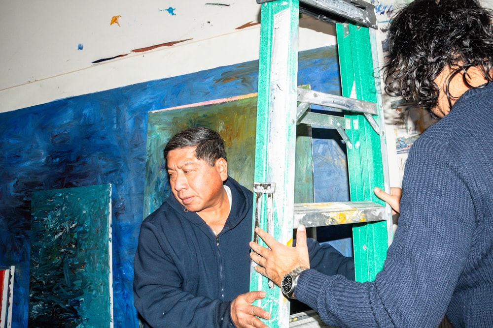 a man standing next to a woman in front of a painting