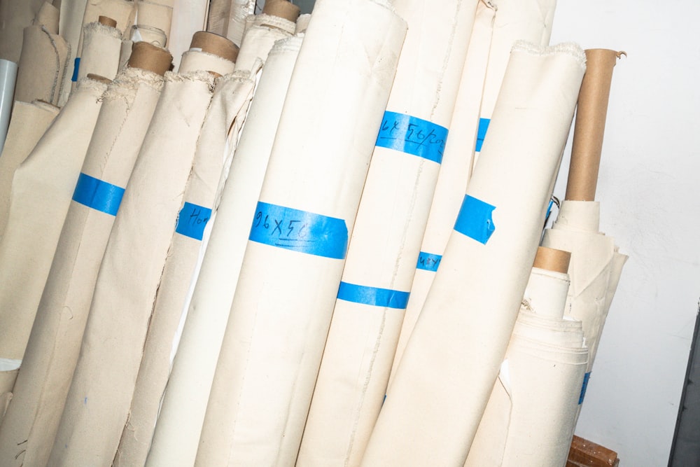 a bunch of white umbrellas with blue tape on them