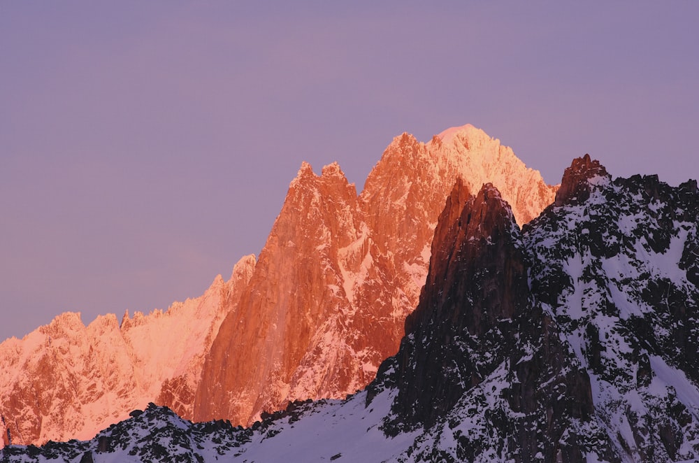 a snow covered mountain with a pink sky in the background