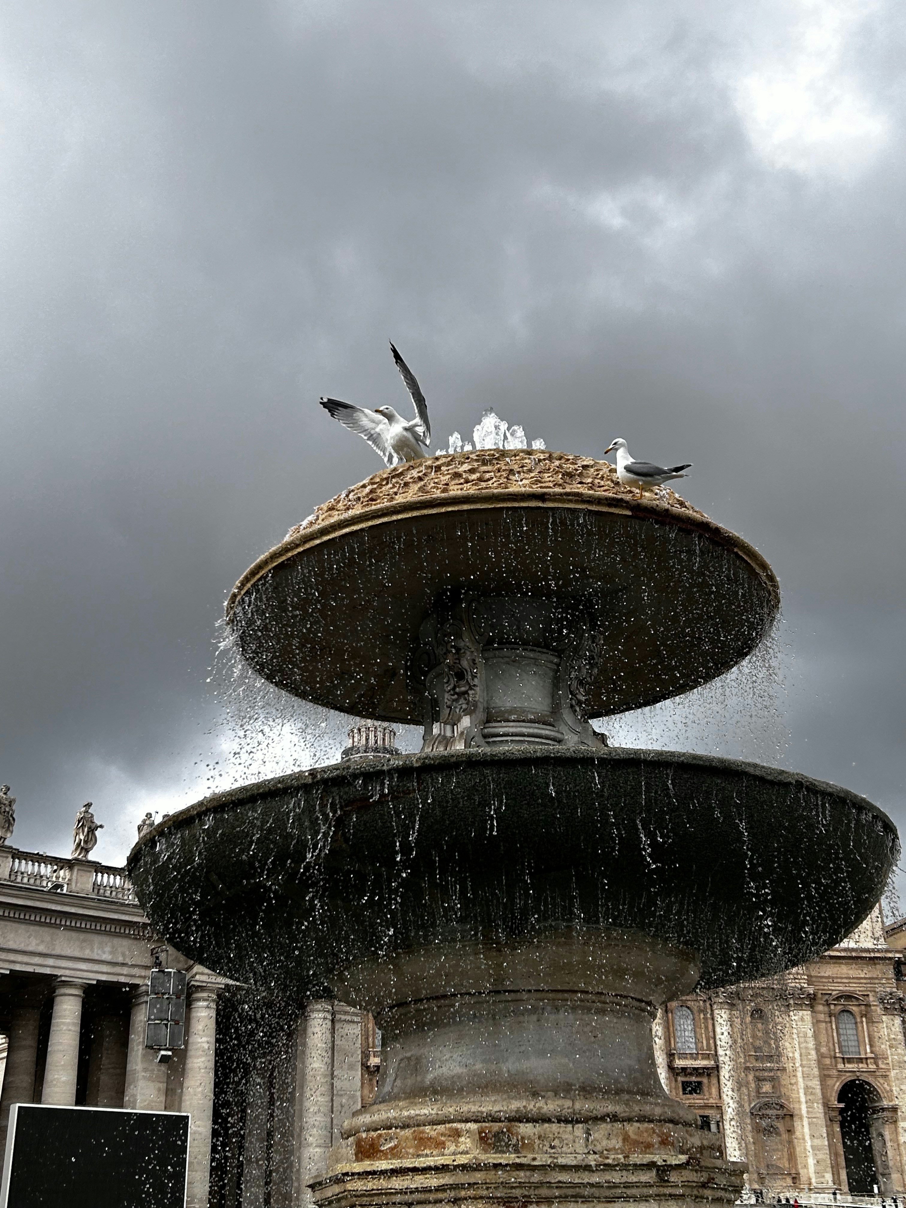 a fountain with birds sitting on top of it
