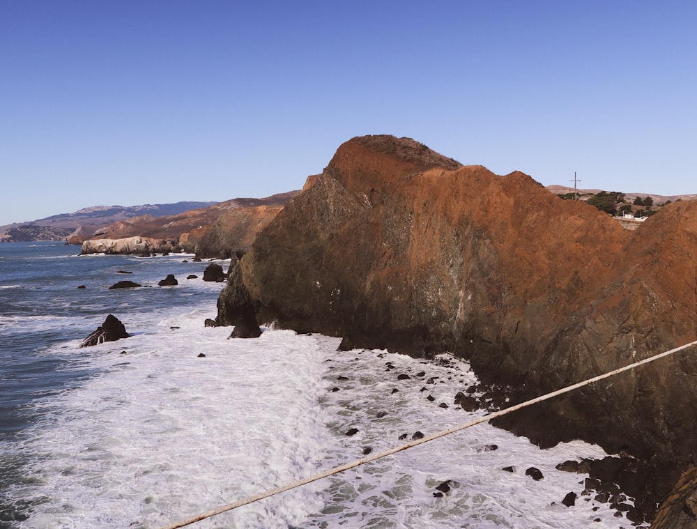 a rope is attached to a rock near the ocean