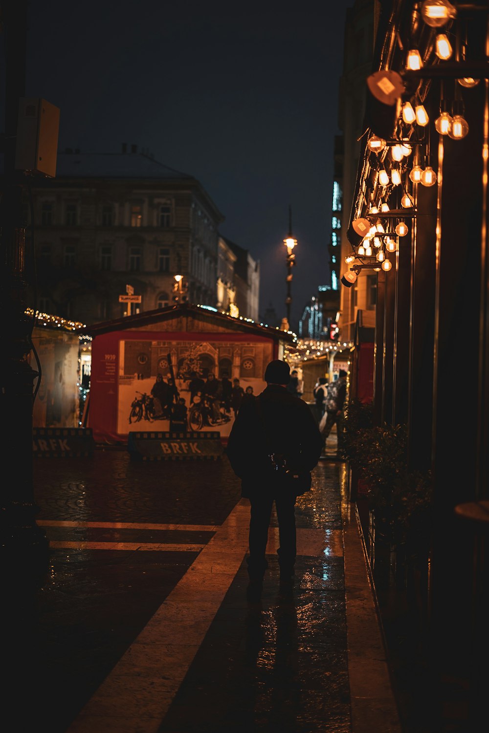 a man walking down a street at night