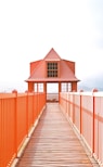 a wooden walkway leading to an orange building