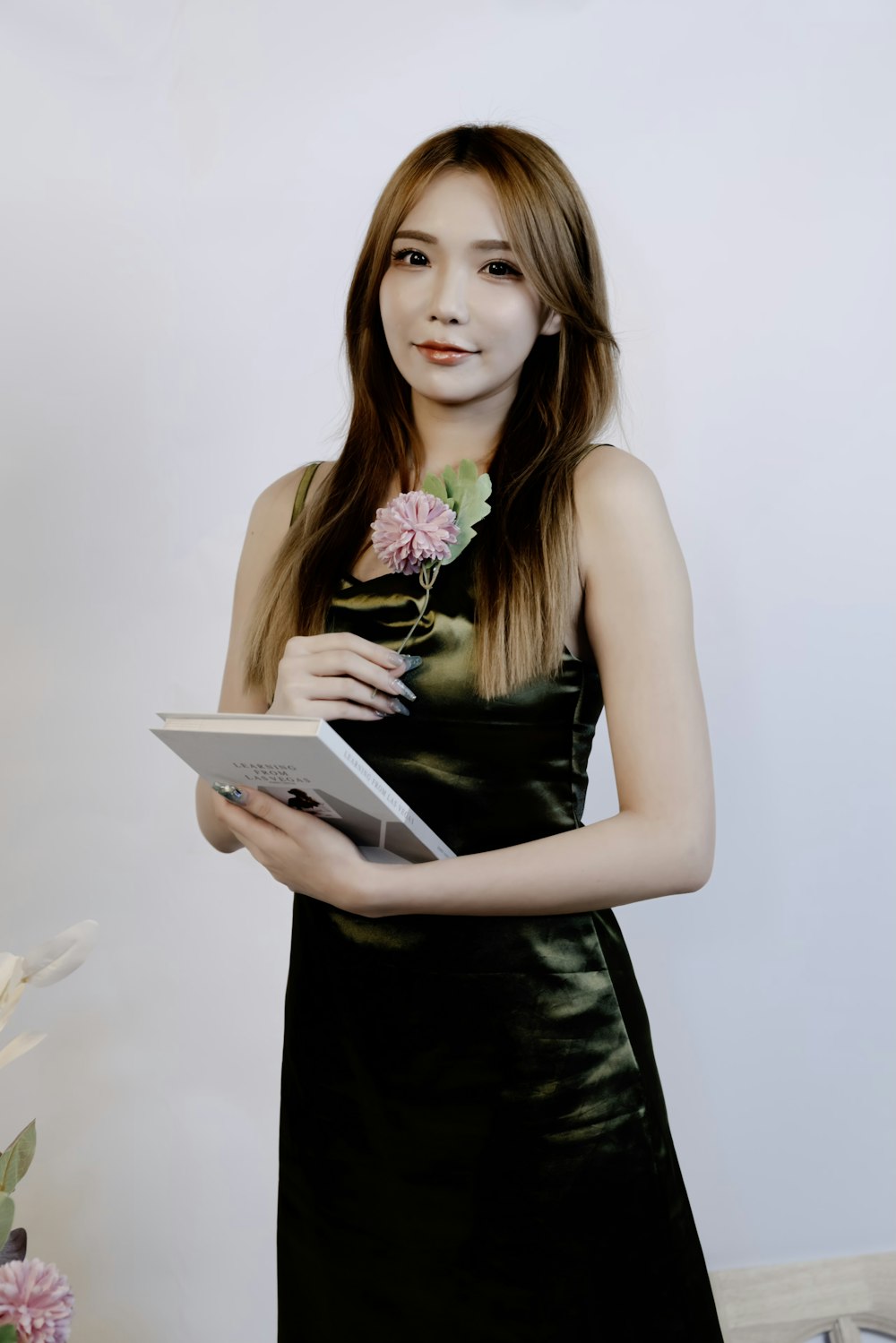 a woman in a black dress holding a book