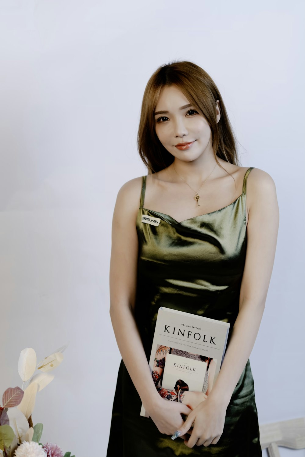 a woman in a green dress holding a book