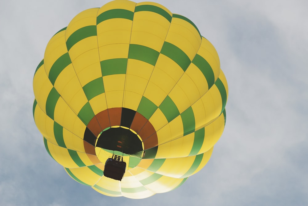 a yellow and green hot air balloon in the sky