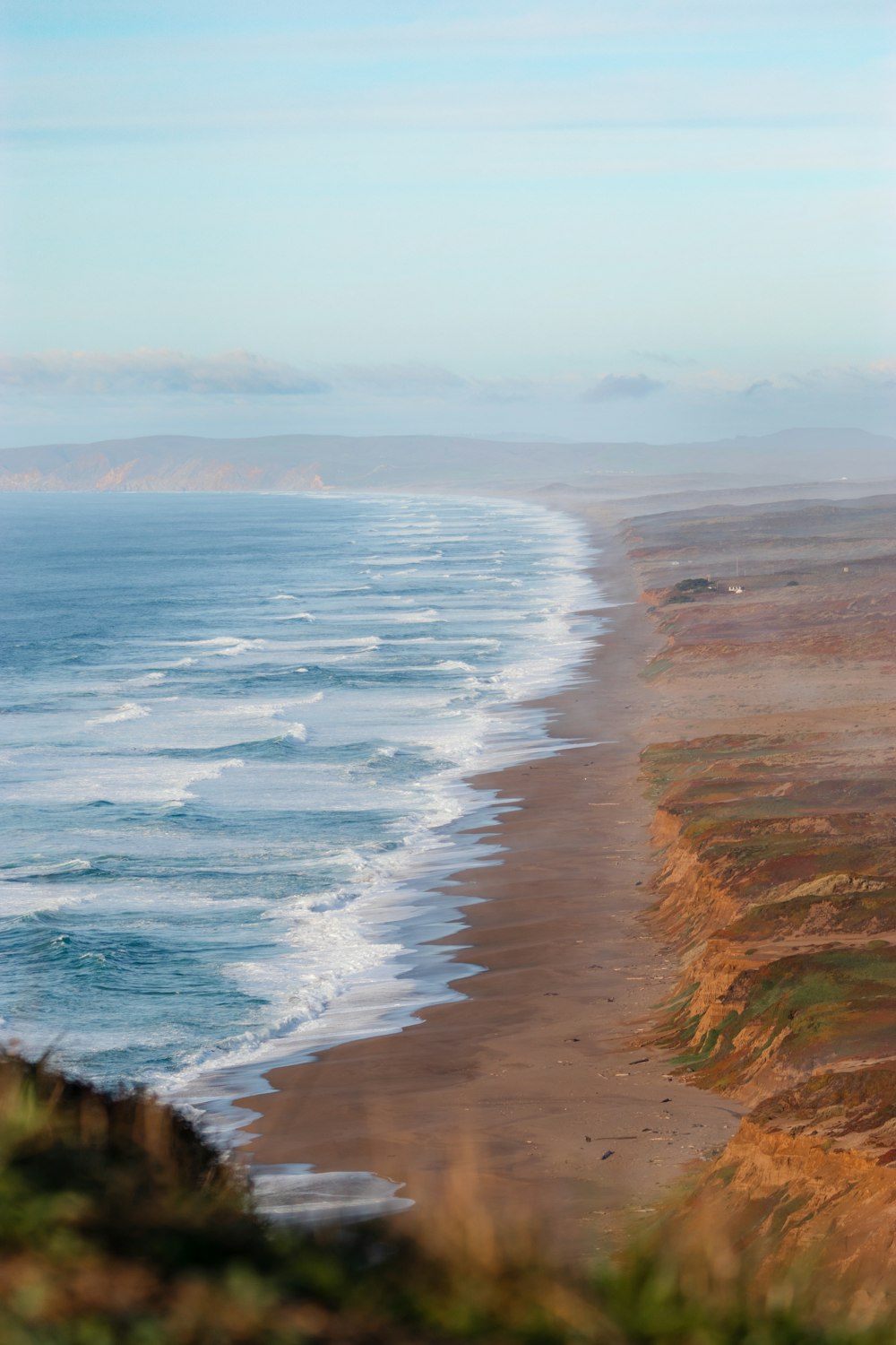 a view of the ocean from the top of a hill