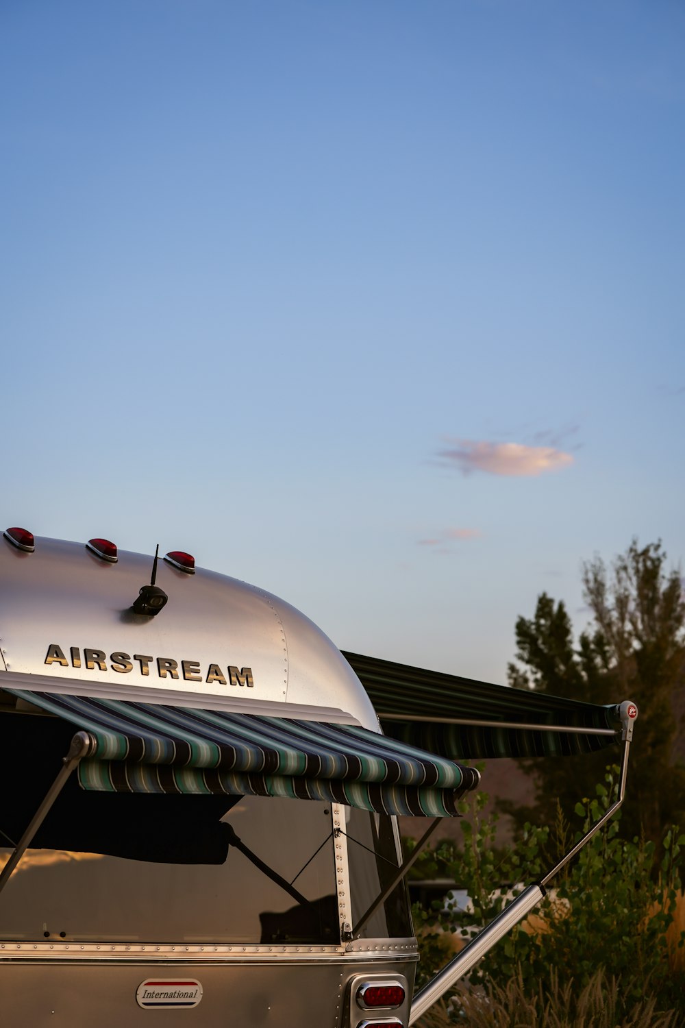 an airstream parked in a field with a blue sky in the background