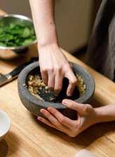 a person putting food in a bowl on a table