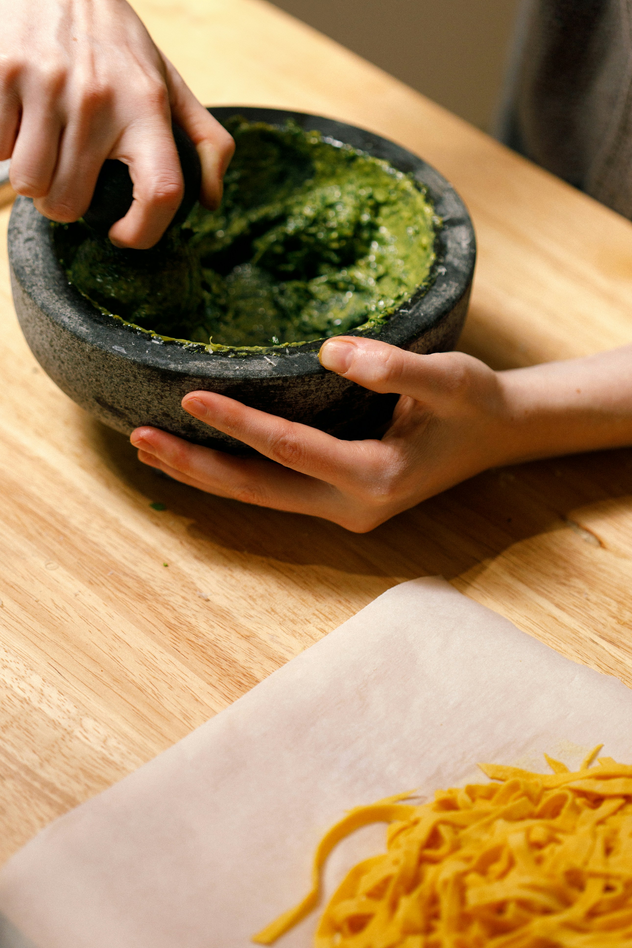 a person holding a bowl of food on top of a wooden table