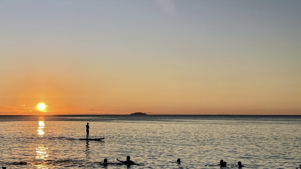 a group of people riding surfboards on top of a body of water