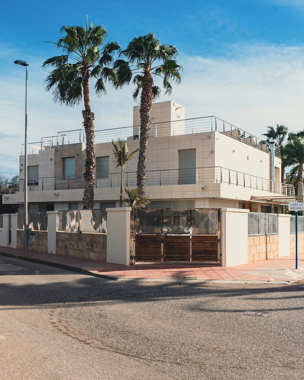 a large white building with three palm trees in front of it