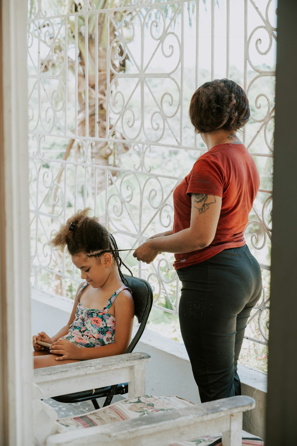 a woman standing next to a little girl in a chair