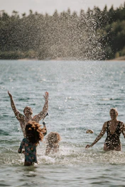 a group of people in the water playing with a frisbee