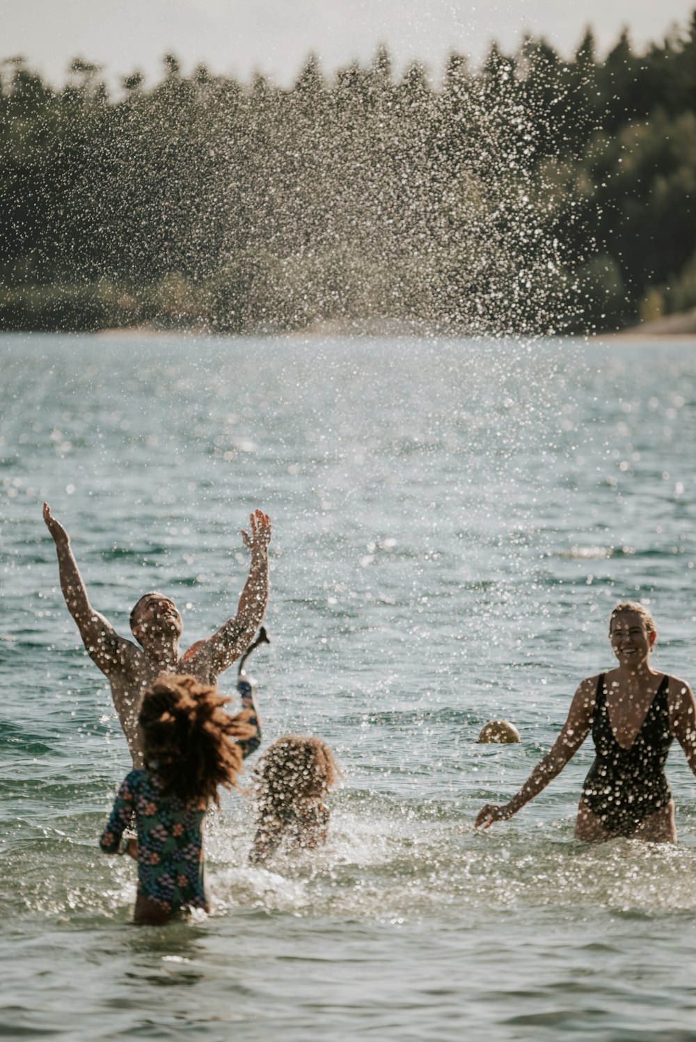 a group of people in the water playing with a frisbee