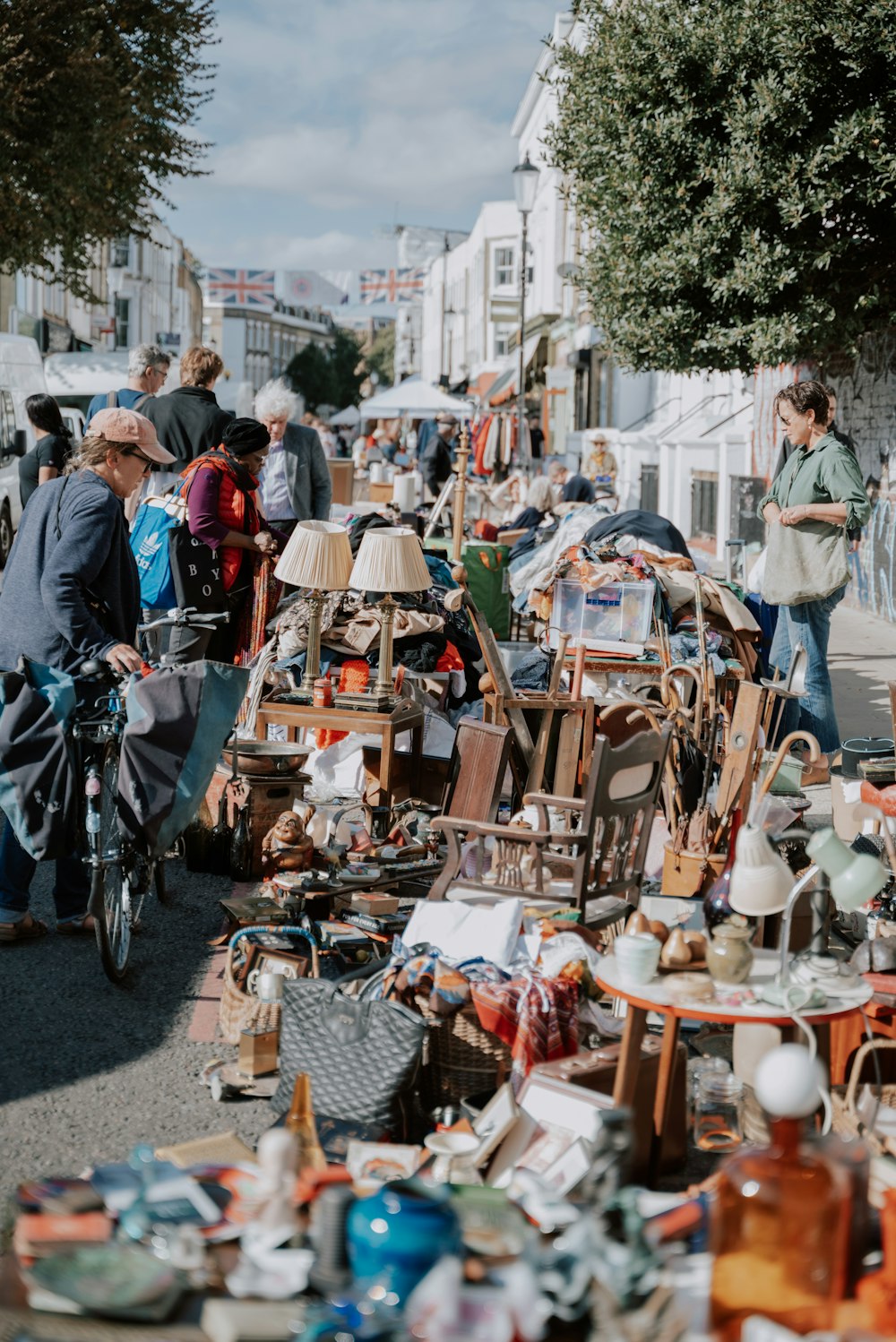 a group of people walking down a street next to a pile of items