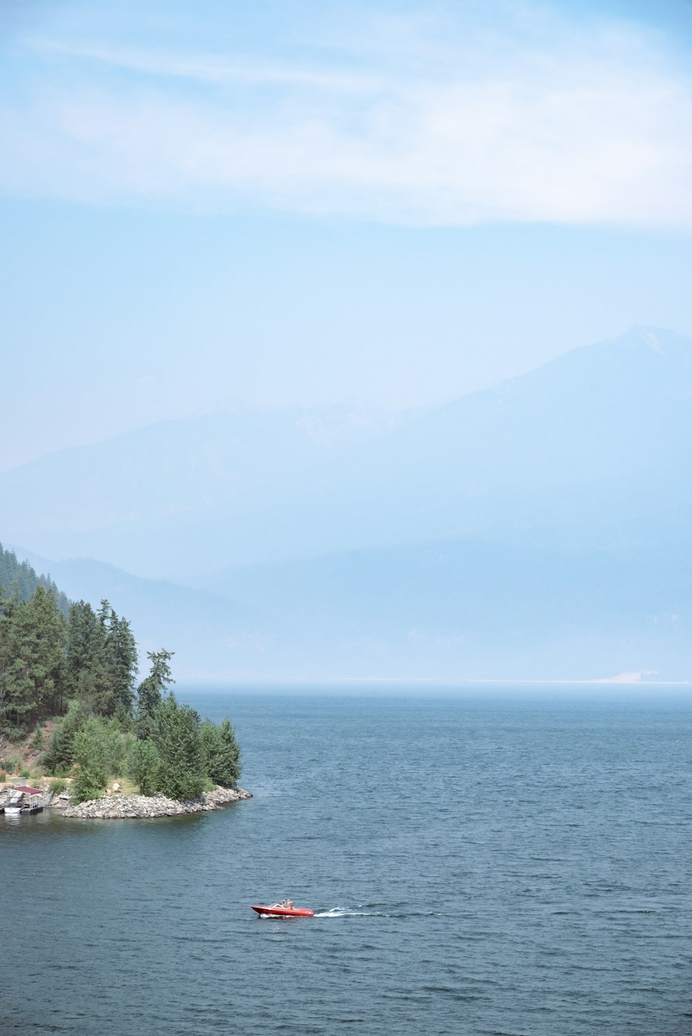 a small boat floating on top of a large body of water