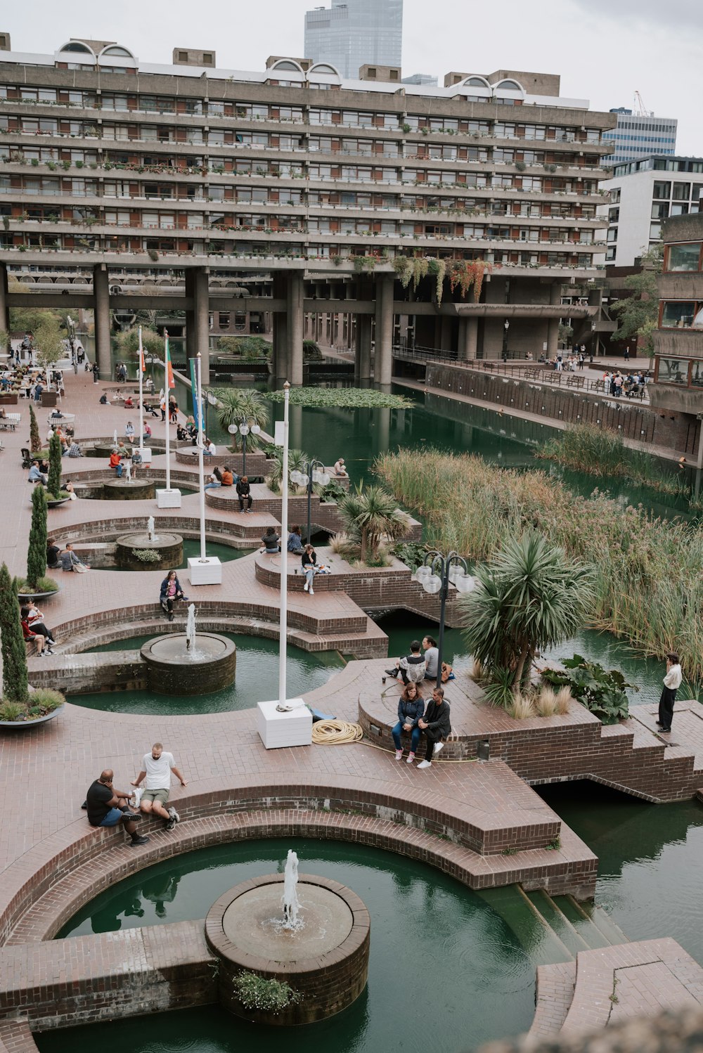 a group of people sitting on benches next to a river