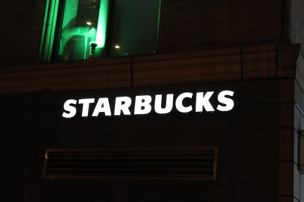 a starbucks sign is lit up at night