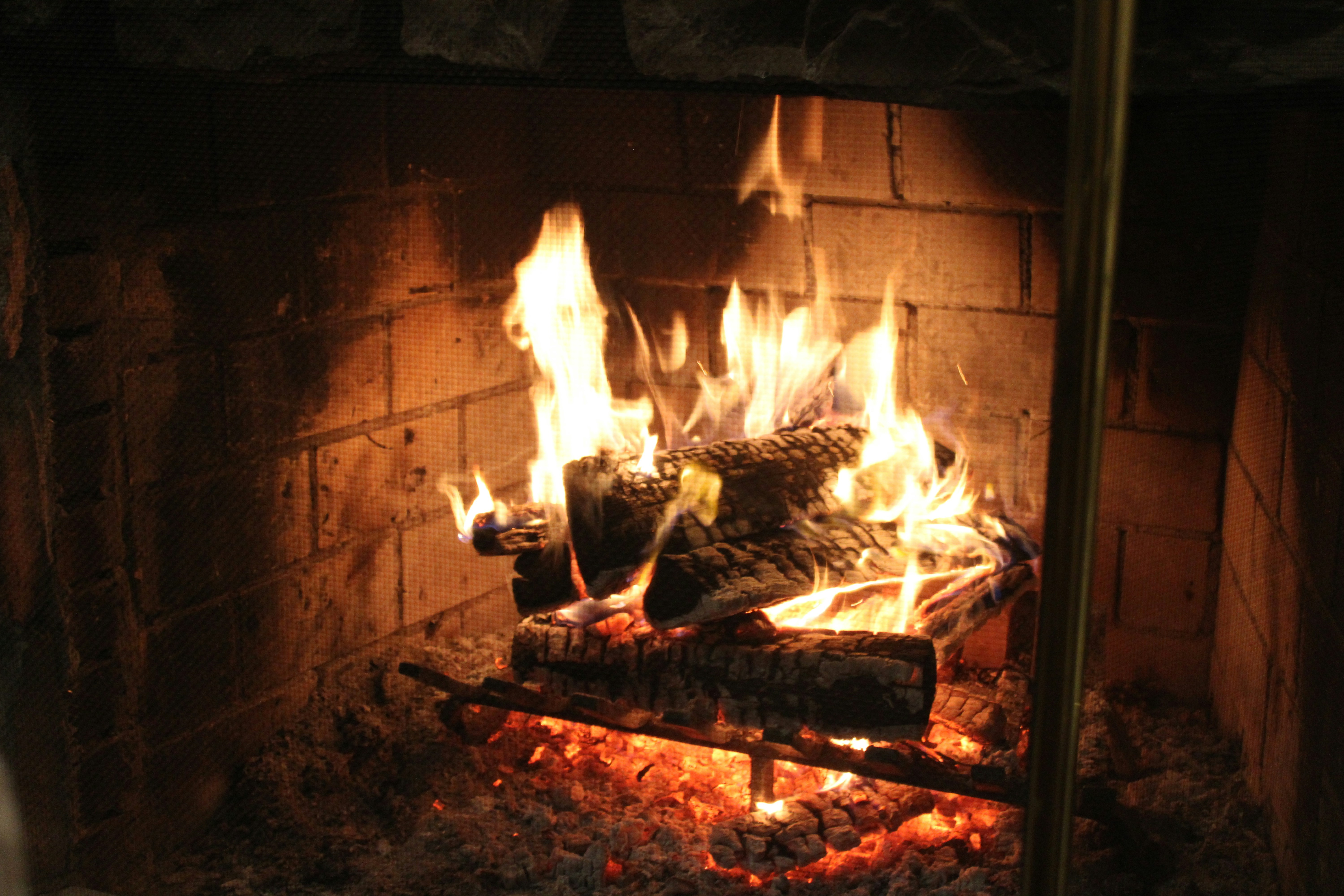 a fire burning in a fireplace with rocks and logs