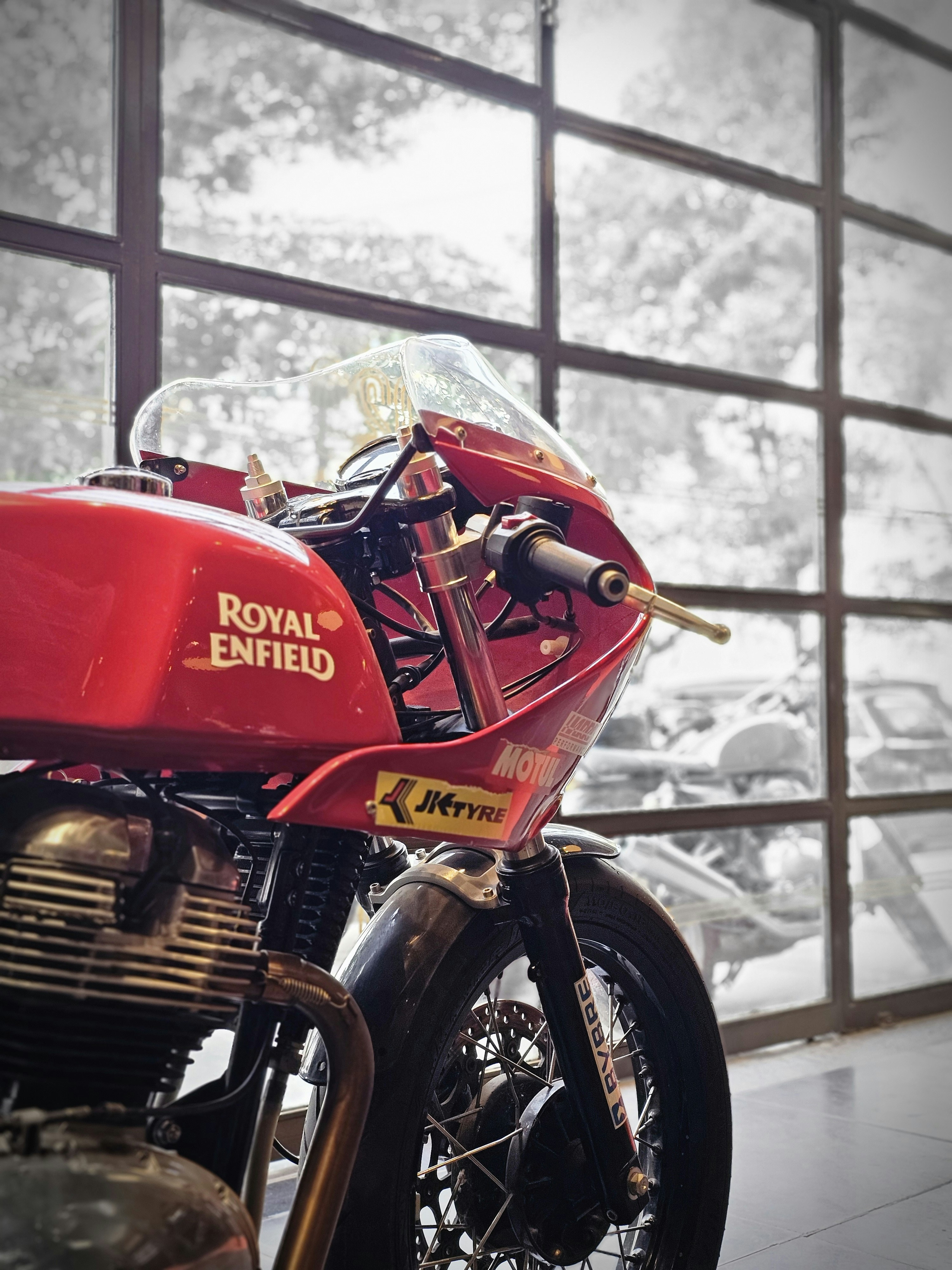 a red motorcycle parked in front of a window