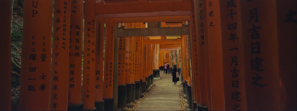 a group of people walking through a tunnel of orange tori tori tori tori tori tori
