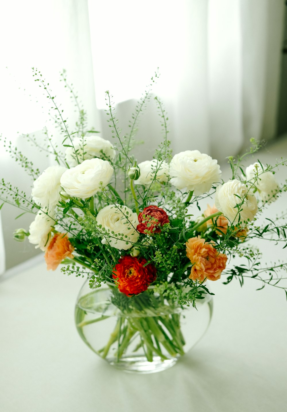 a vase filled with lots of white and orange flowers