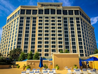 a large building with a lot of chairs and umbrellas in front of it