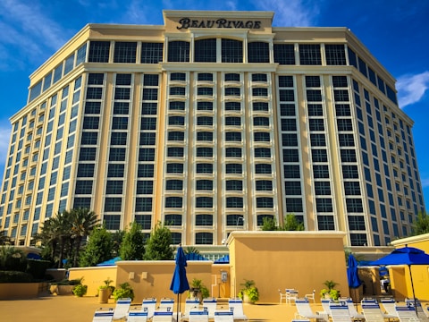 a large building with a lot of chairs and umbrellas in front of it