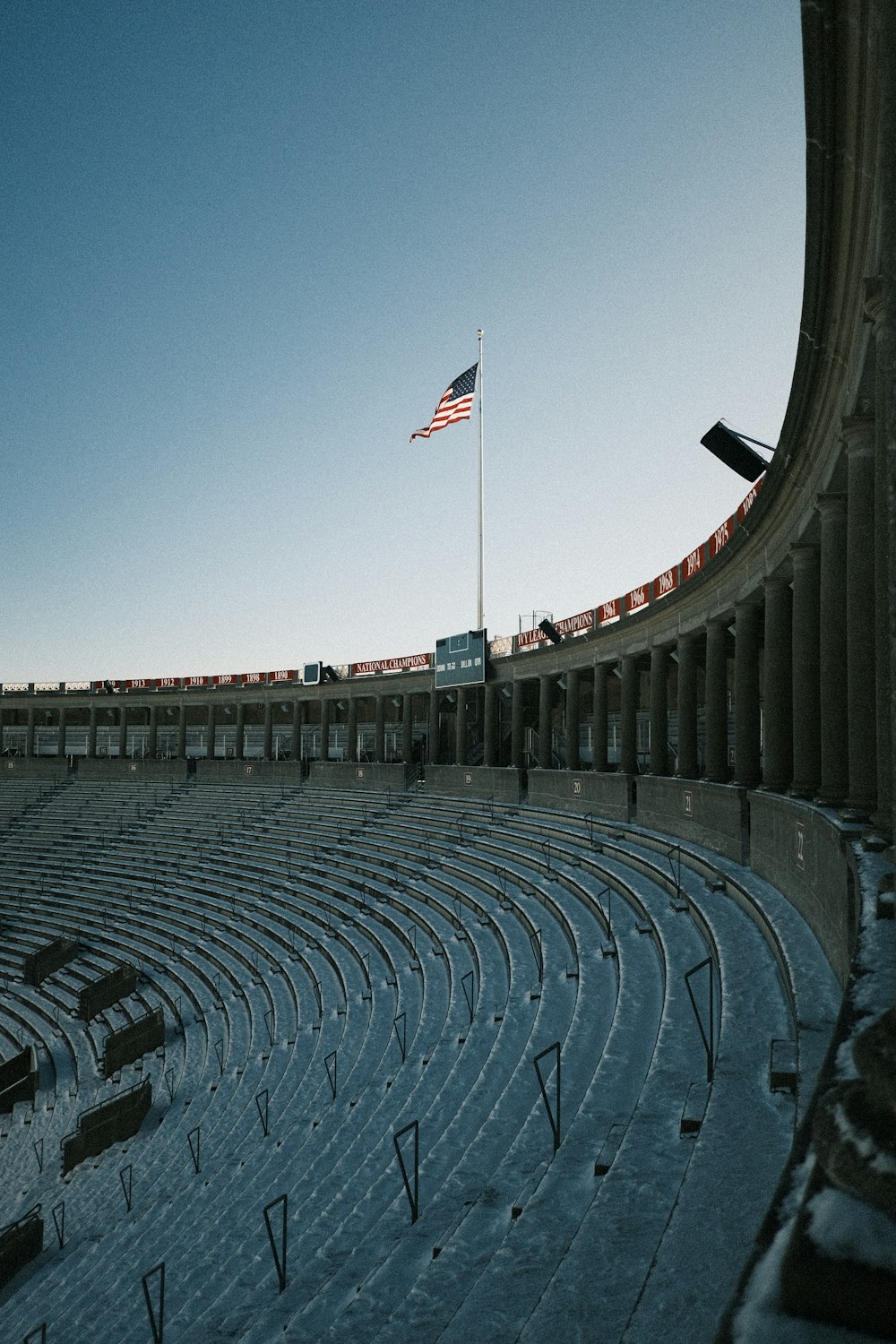 an empty stadium with snow on the ground