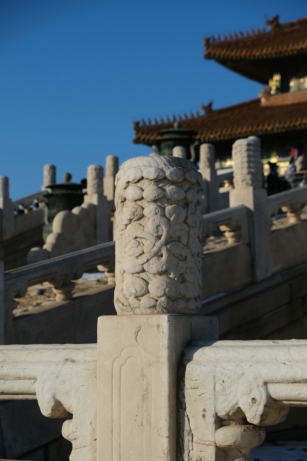 a close up of a stone fence with a building in the background