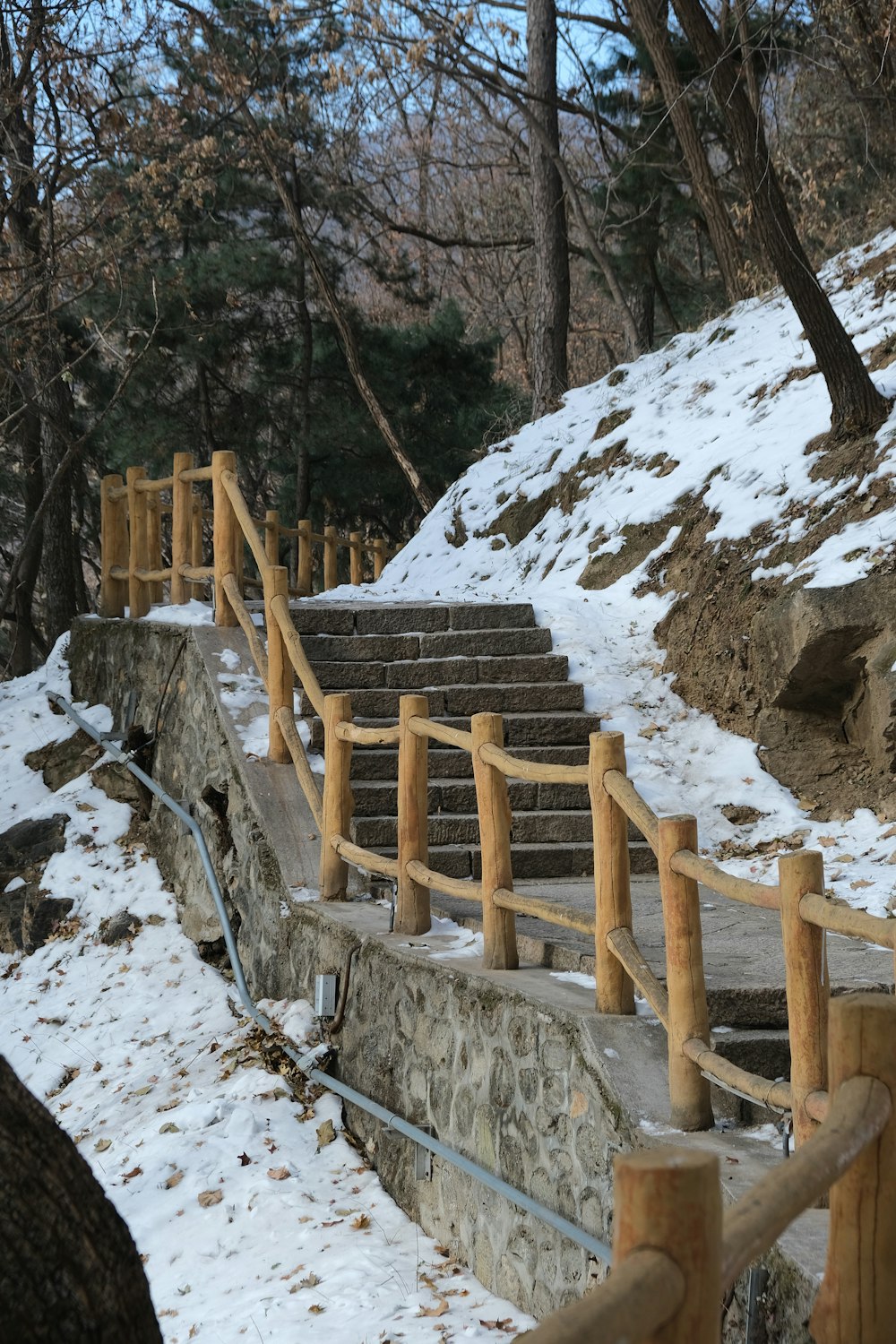 a set of stone steps leading up to a snow covered hill