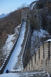 a man walking up a snow covered hill
