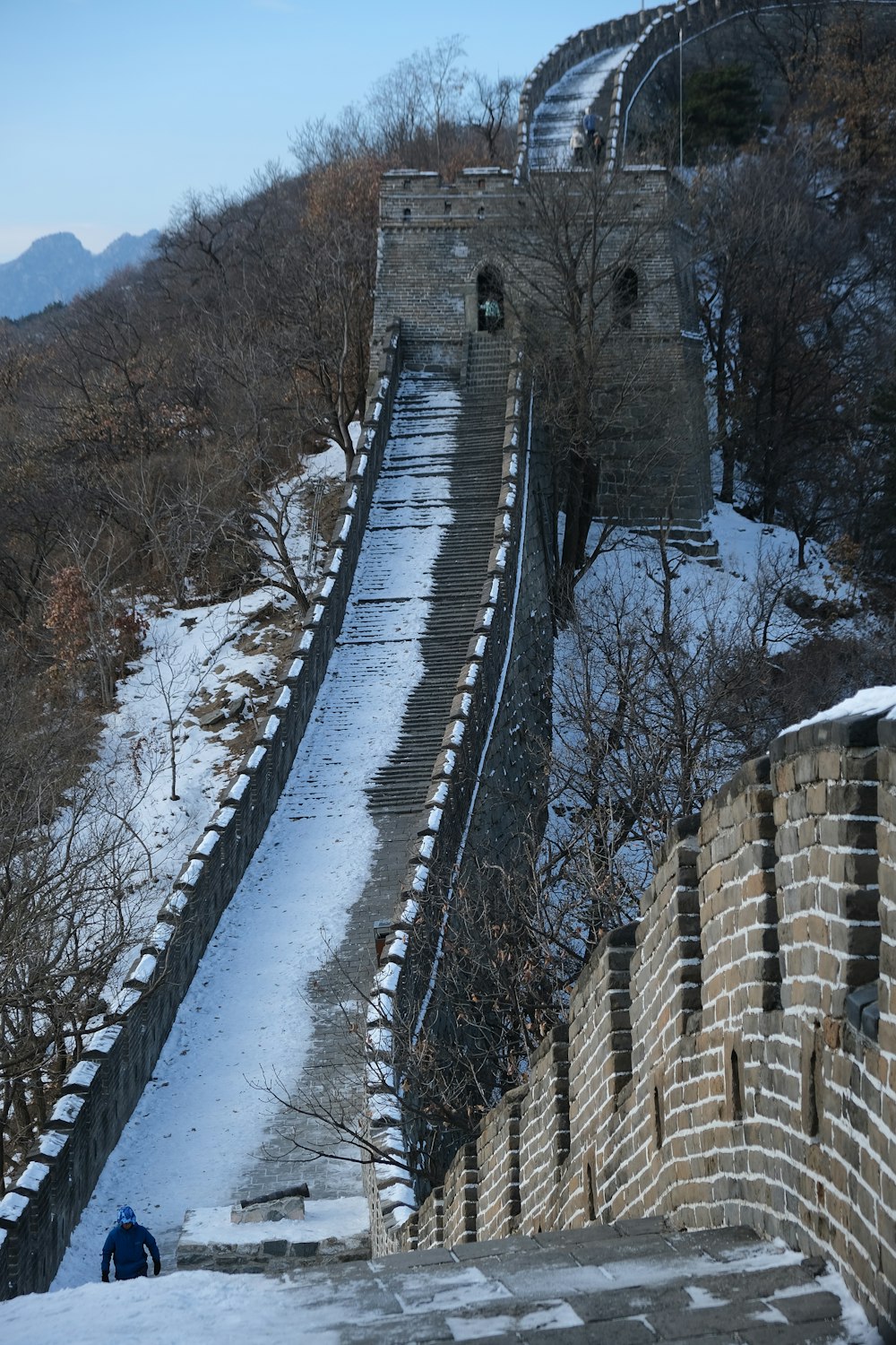 a man walking up a snow covered hill