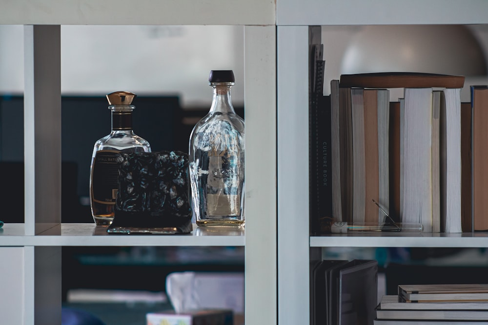 a bottle of liquor sitting on top of a book shelf