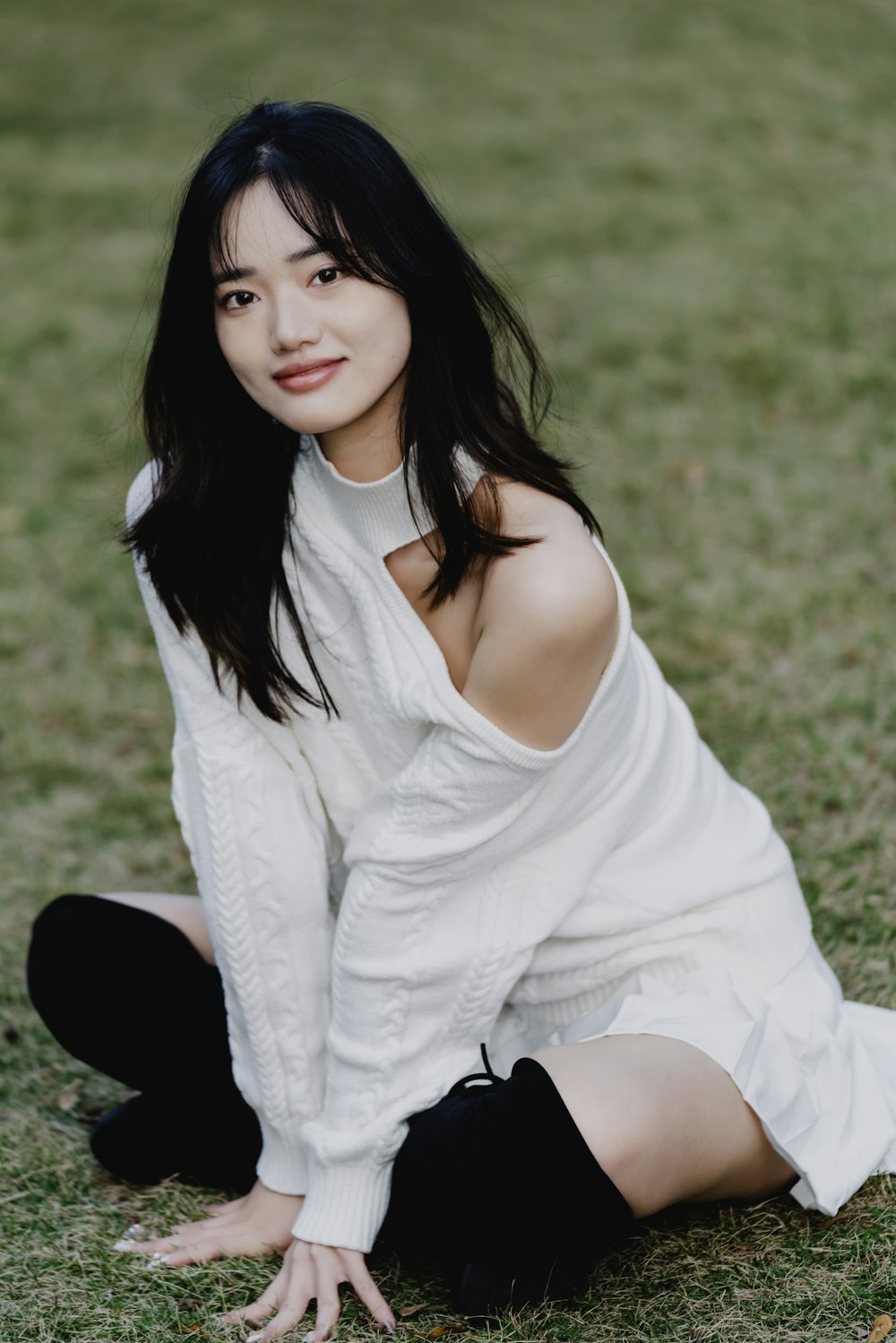 a woman sitting on the ground posing for a picture