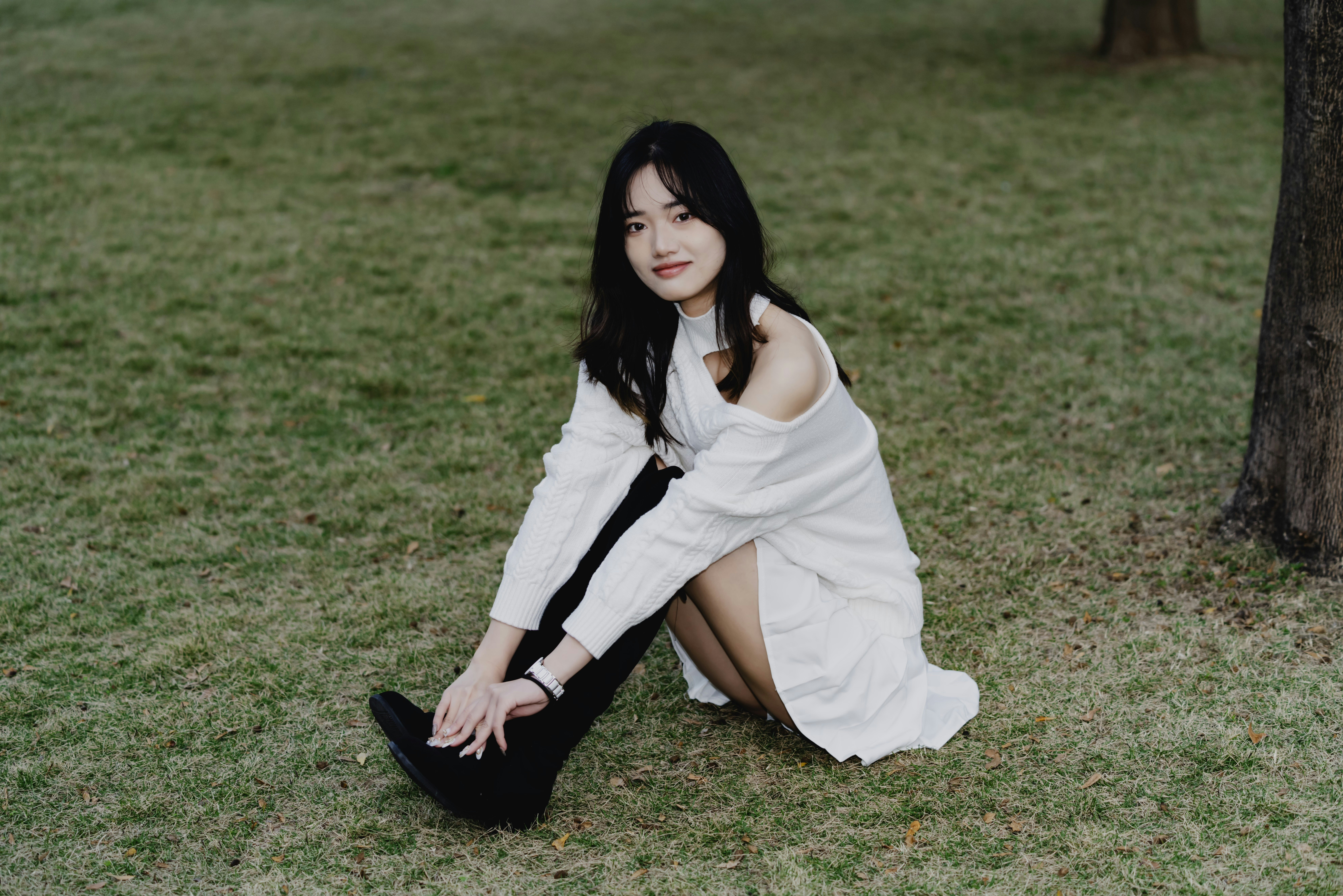 una mujer con un vestido blanco sentada en la hierba